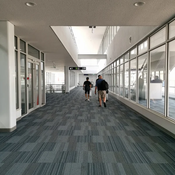 Deux personnes marchant dans un couloir d'aéroport.