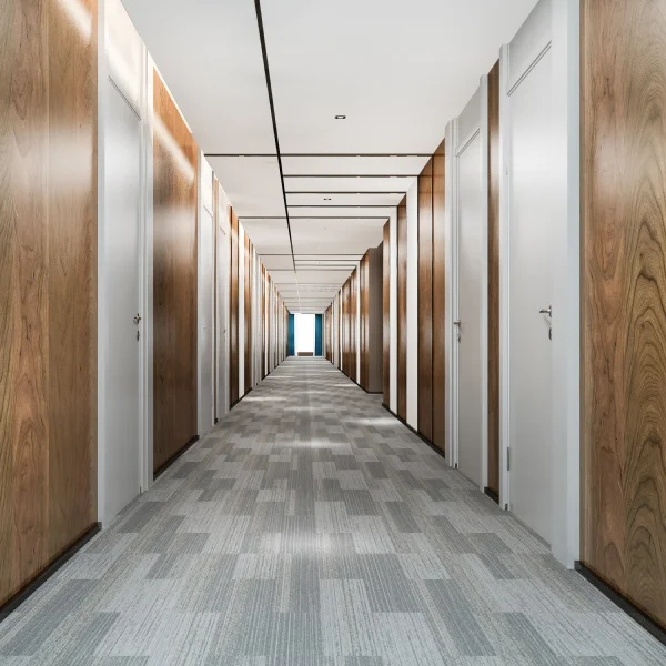 Un long couloir avec des portes en bois et un tapis, créant une ambiance chaleureuse et accueillante.