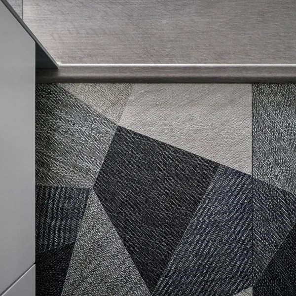 Salle de bain moderne avec un motif gris et noir, mettant en valeur un tapis mural élégant.